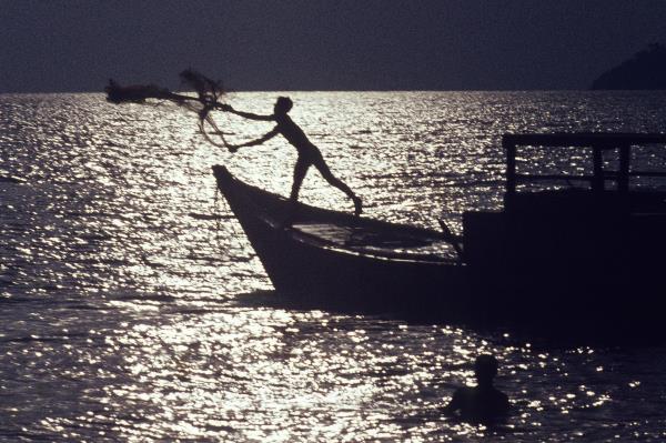 Thailand. Ein Fischer wirft sein Netz aus.